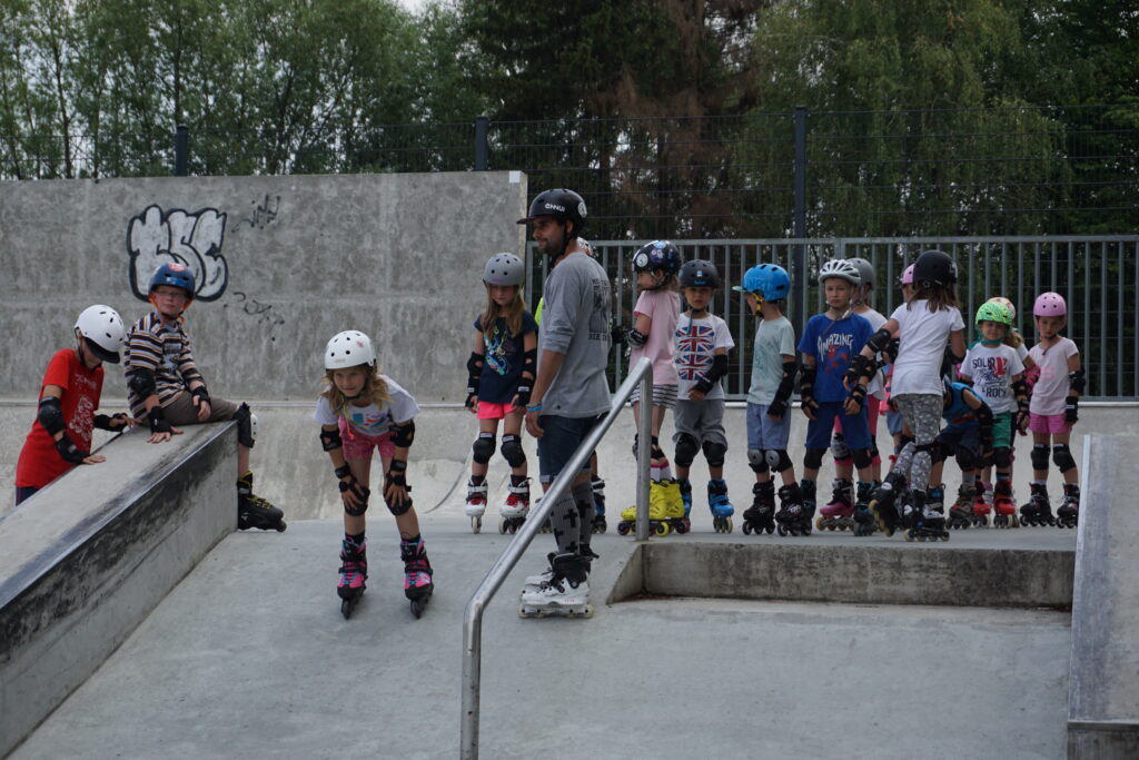 instruktor z dziećmi na skateparku